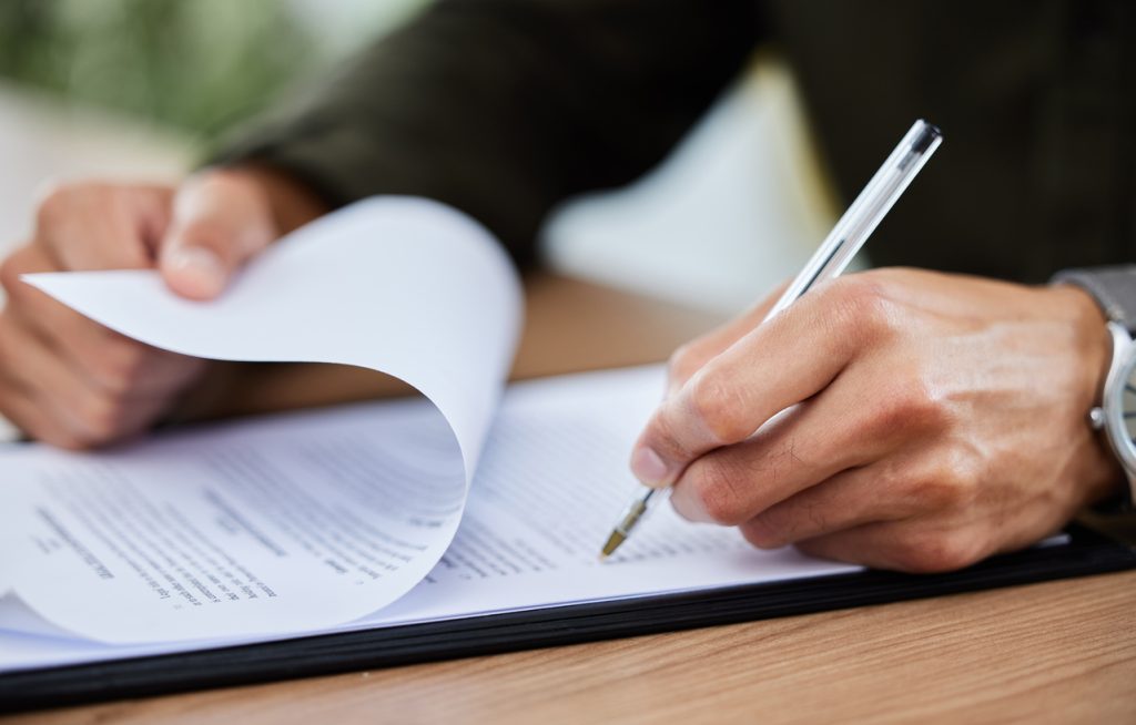 Closeup shot of an unrecognisable man going through paperwork