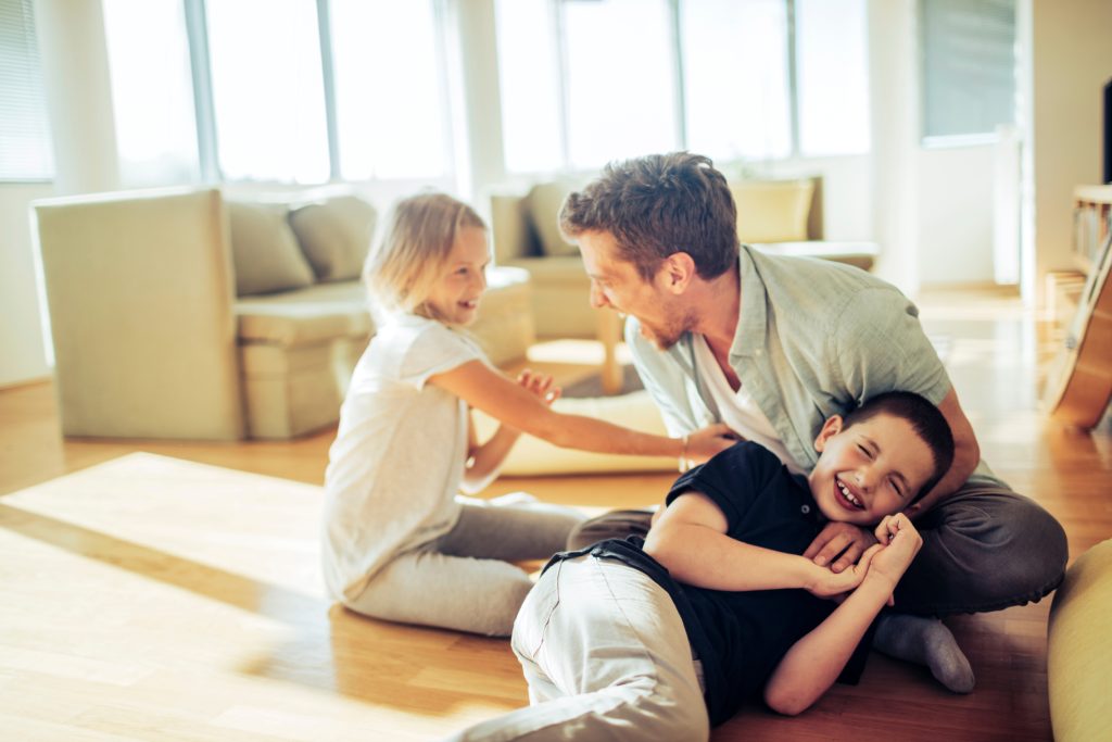 Close up of a happy father playing with his children